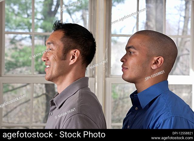 Portrait of the side view of two young businessmen standing facing left