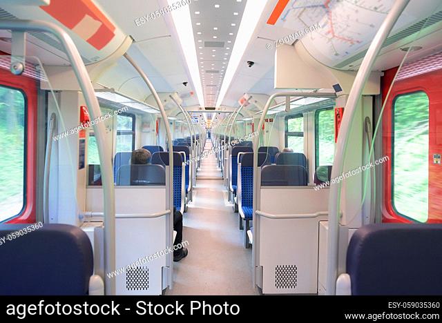 Public transport of person theme image with a German regional train interior, with chairs aligned on two rows and a very long corridor between them