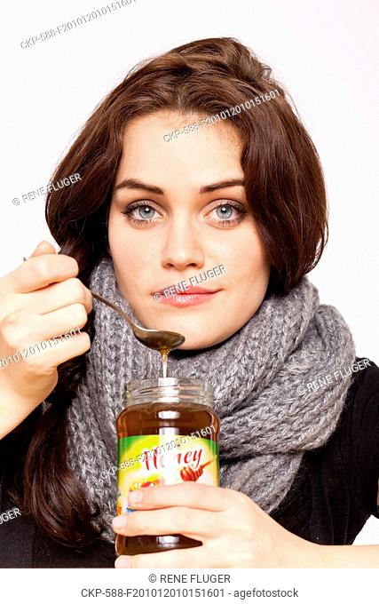 A beautiful young woman, lady, girl, cold, runny nose, headache, tea, honey, spoon, scarf