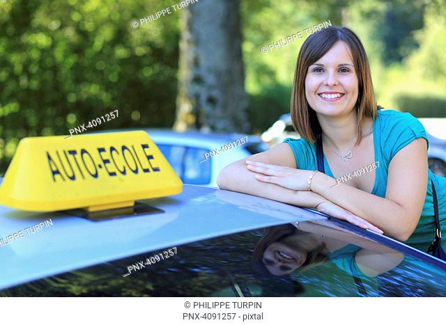 Young woman and driving school car