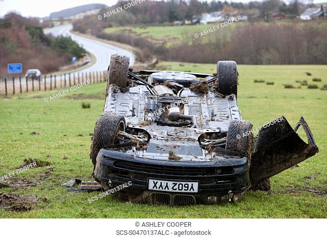 A BMW car crashed on its roof in the middle of a field after leaving the road at high speed on the A66 near Keswick Cumbria UK
