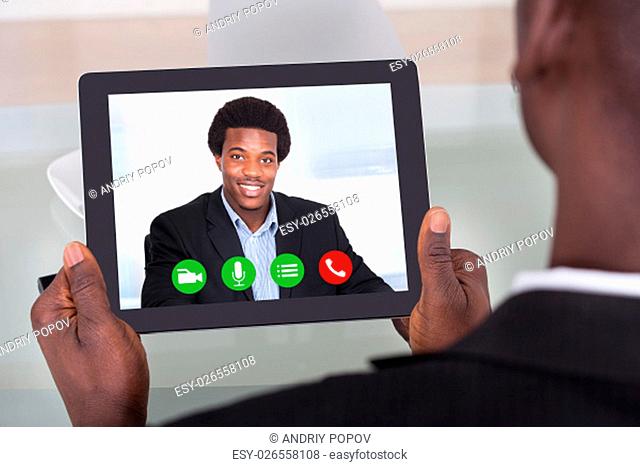 Close-up Of A Businessman Holding Digital Tablet On Desk
