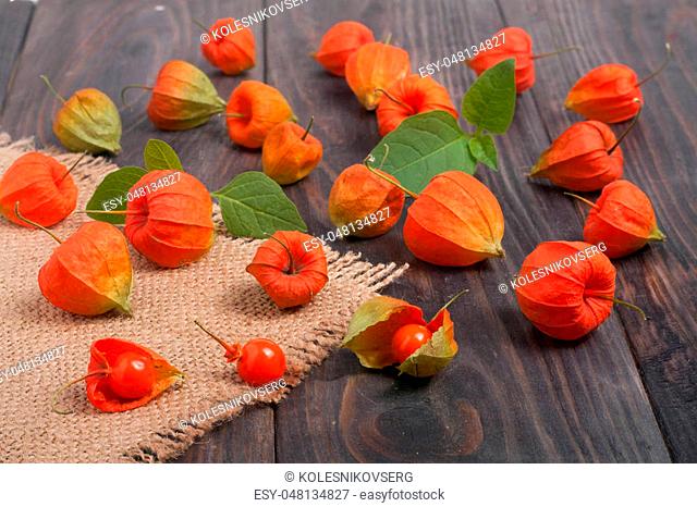 physalis scattered on a dark wooden table