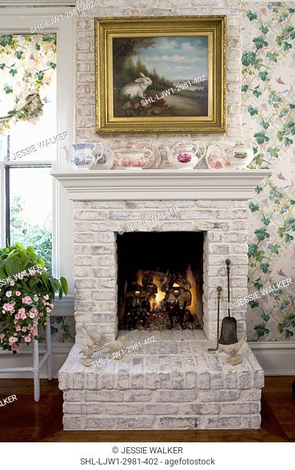 FIREPLACES: white painted brick fireplace in kitchen eating area, ivy wallpaper, rabbit painting, teapots on mantel, raised hearth