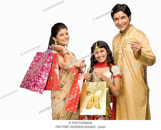 Couple and their daughter carrying shopping bags and credit card