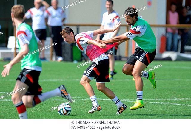 Mesut Oezil (l) and Sami Khedira during an open training session for visitors and fans of the German national soccer team at the training center in Santo Andre