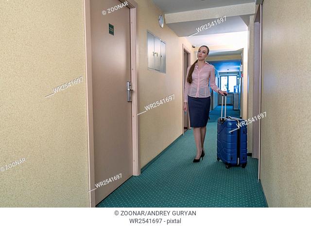 Pretty business lady looking for room in hotel
