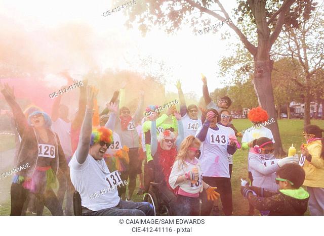 Playful runners throwing holi powder at charity run in park