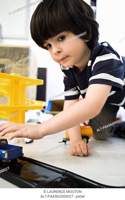 Little boy playing with toy cars, close-up