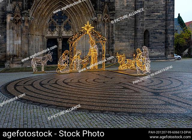 01 December 2020, Saxony-Anhalt, Magdeburg: There is an illuminated nativity scene on the cathedral square. It is a donation of the Protestant Church District...