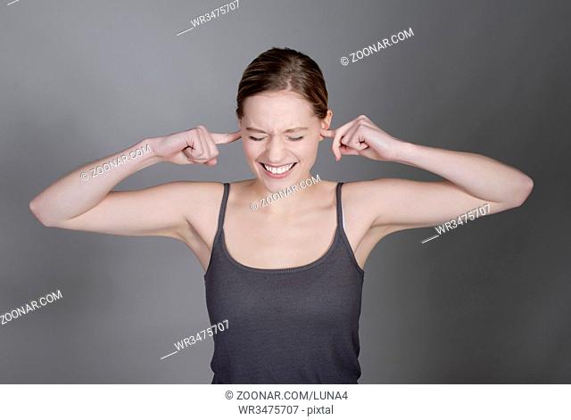 junge Frau hält sich die Ohren zu  pretty young woman holding her ears with fingers