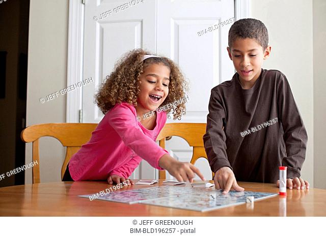 Mixed race children playing board game together