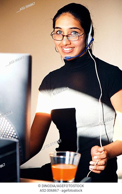 Woman on computer with headphones