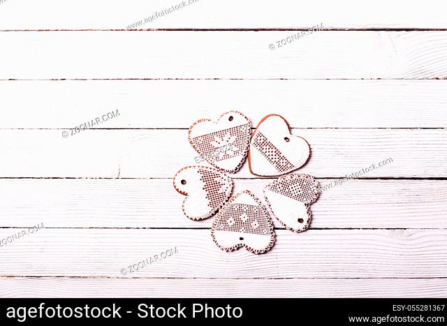 Gingerbread cookies in shape of heart with icing on a wooden background