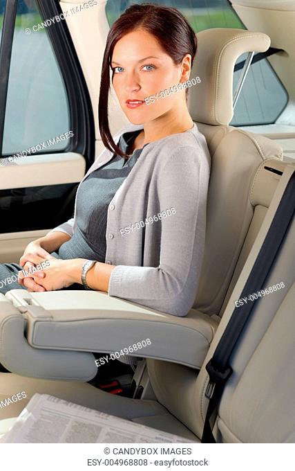 Executive woman manager sitting in car backseat