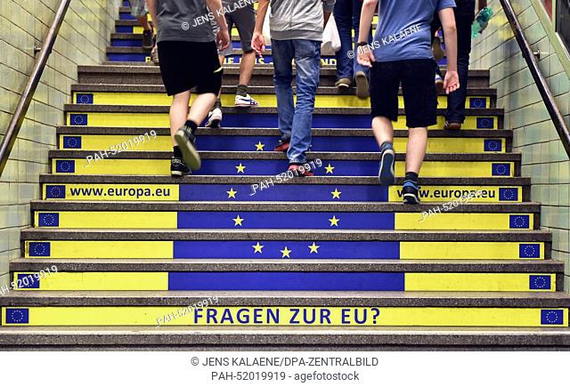 A view of an advert showing the flag of the European flag, a website and the question ""Questions oaboutn the EU?"" on a flight of stairs at subway station...