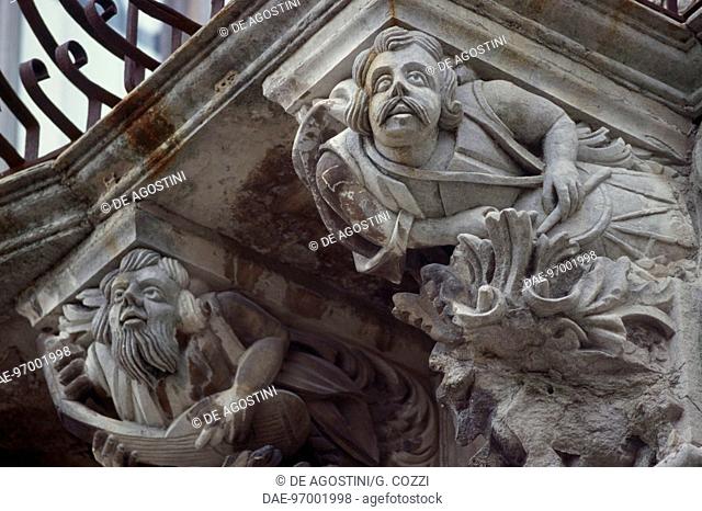 Baroque sculptural decoration with mascarons, wrought-iron balcony, Cosentini Palace, Ragusa, Sicily, Italy