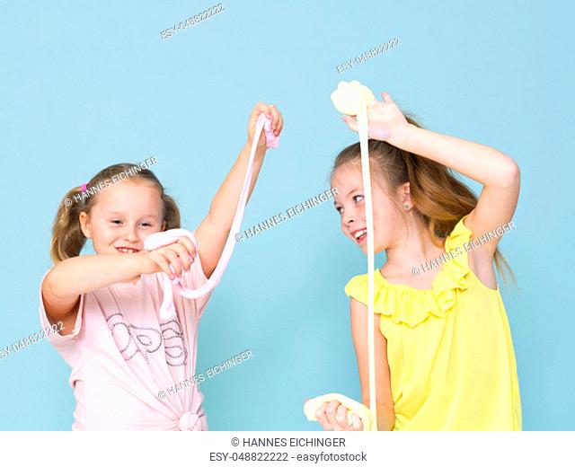 two beautiful girls playing with homemade slime and having a lot of fun