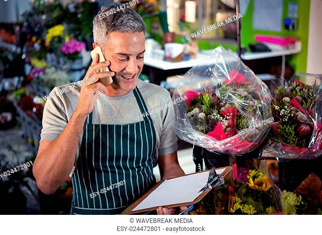 Male florist taking order on mobile phone