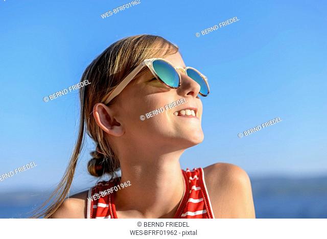 Croatia, Lokva Rogoznica, portrait of sunbathing girl on the beach wearing sunglasses