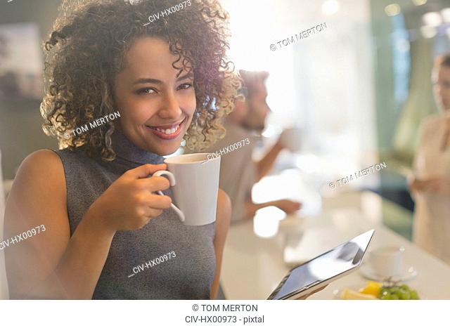 Portrait smiling businesswoman drinking coffee using digital tablet