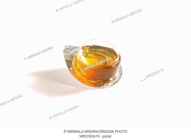 Madhu shahad honey sweet sticky yellowish substance in plastic container on white background