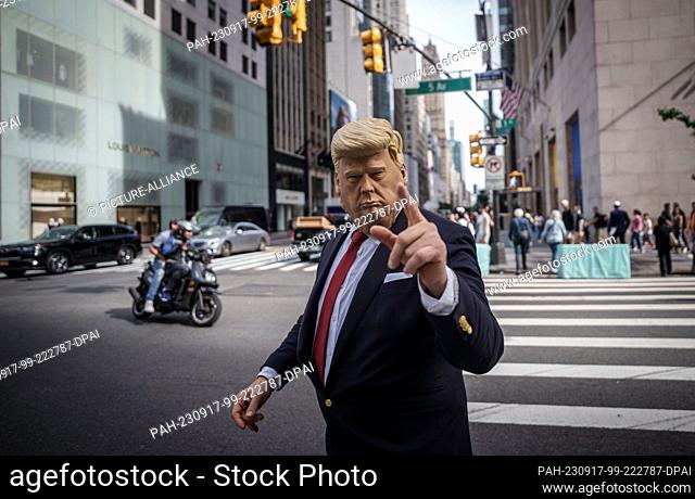 16 September 2023, USA, New York: A man wearing a Donald Trump mask directs traffic in front of Trump Tower on 5th Avenue in Manhattan