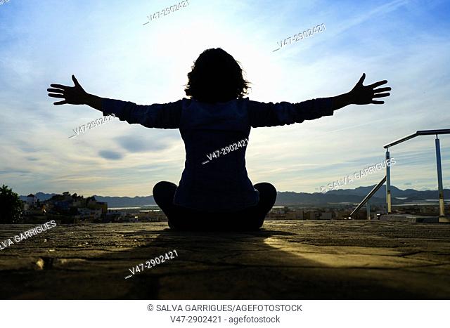Silhouette of woman with arms outstretched, Aguilas, Murcia, Spain