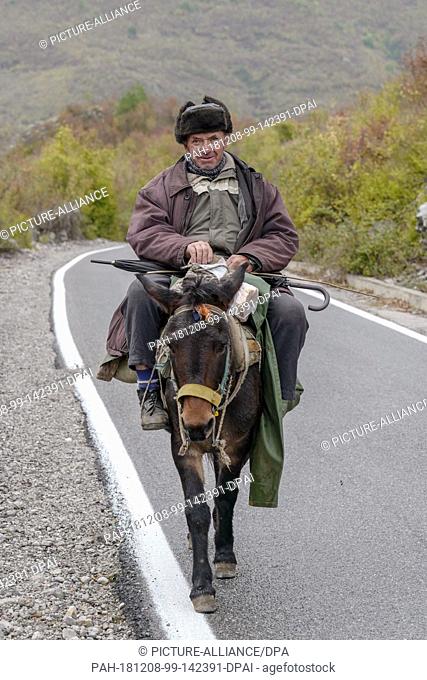 27 October 2018, Albania, Malësia e Madhe: A man rides a mule in Malësia e Madhe in the Albanian Alps. Photo: Peter Endig/dpa-Zentralbild/ZB