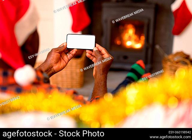 Back view of african american senior couple using smartphone with copy space at christmas time
