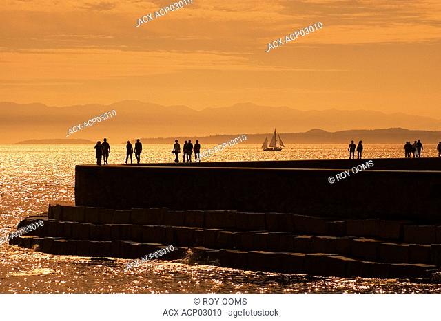 People walkng along the Breakwater at sunset, victoria, vancouver island, british columbia, canada