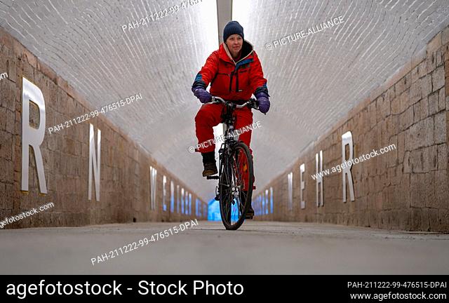 22 December 2021, Saxony, Chemnitz: Artist Anke Neumann rides her bike in the newly designed pedestrian tunnel at Chemnitz central station