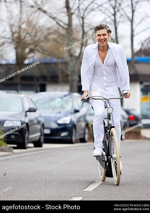 07 March 2023, North Rhine-Westphalia, Sankt Augustin: Jeremy Fragrance, entrepreneur, web video producer and influencer, rides his bike near his office