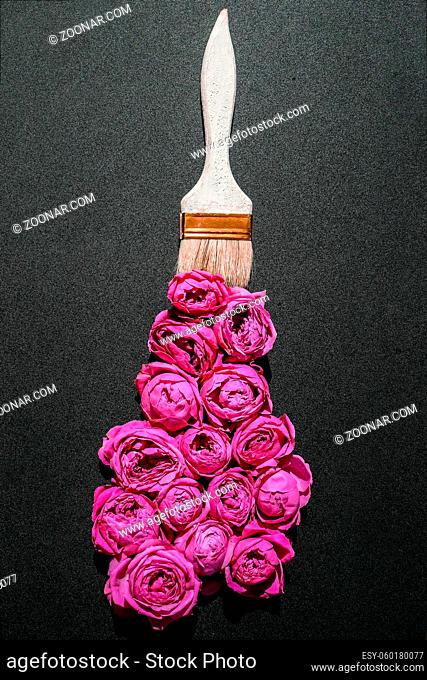 Paint brush drawing with pink flowers on black background. The concept of spring and international womens mothers day. Floral painting and decoration creative