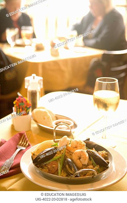 Spanish dish of paella and a glass of chardonnay wine, Patricks Side Street Cafe, Los Olivos, Santa Ynez Valley, California