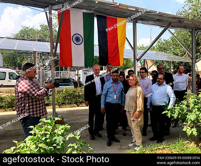 09 June 2023, India, Neu Delhi: Development Minister Svenja Schulze (SPD, M) inspects a photovoltaic system with charging station for electric cars and battery...