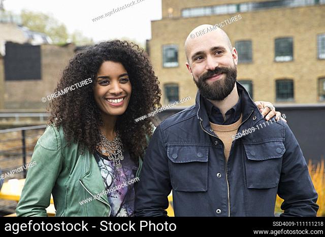 Portrait of woman and man on rooftop patio