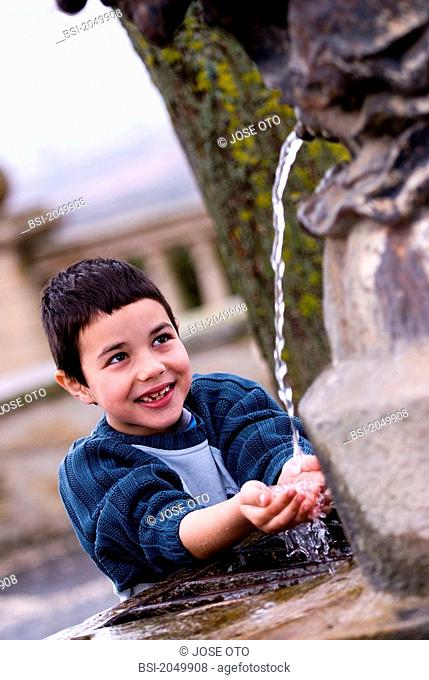CHILD PLAYING WITH WATER OUTDOORS