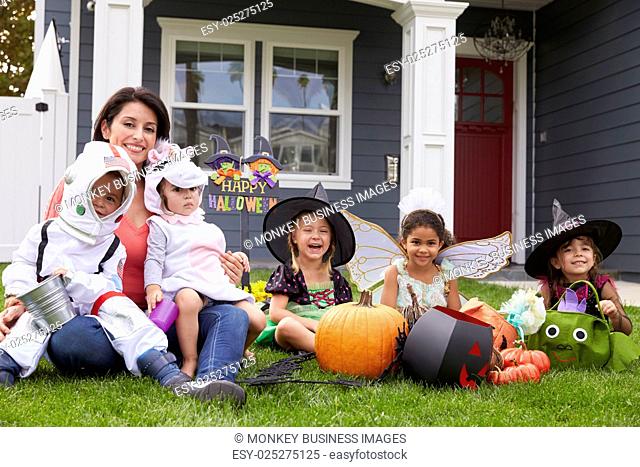 Children Dressed In Trick Or Treating Costumes On Lawn