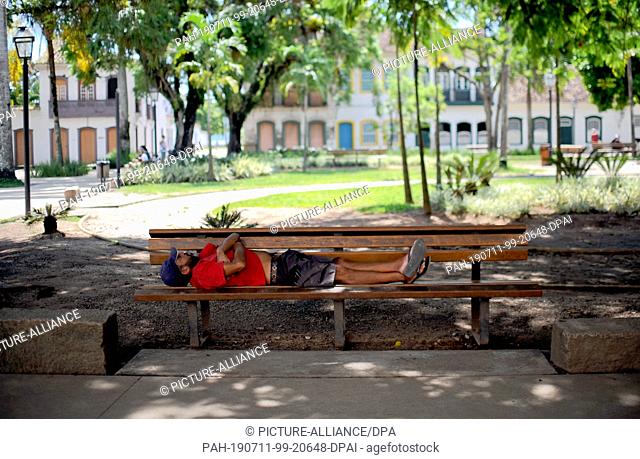 28 January 2018, Brazil, Paraty: A man sleeps on a bench in the old town of Paraty. Photo: Britta Pedersen/dpa-Zentralbild/ZB. - Paraty/Brazil/Brazil