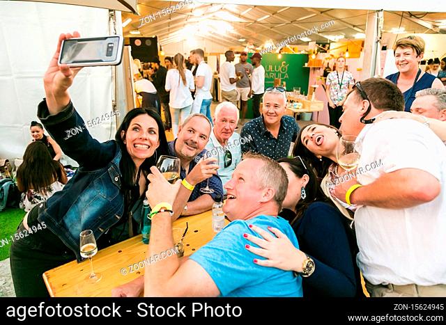 Johannesburg, South Africa - October 14 2017: Friends taking a selfie on their phone and generally enjoying a day out at a Food and Wine Fair