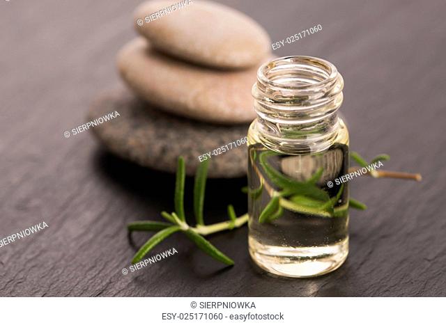 Essential oil with rosemary and fresh green leaves