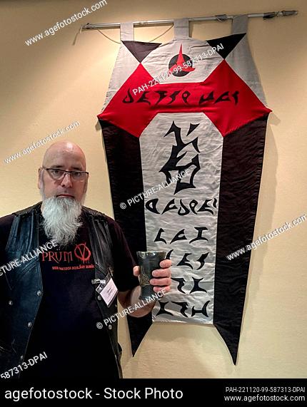 PRODUCTION - 18 November 2022, Saarland, Saarbrücken: Markus Schäfer stands in front of a Klingon house banner in the classroom with a pewter Trinkbecker