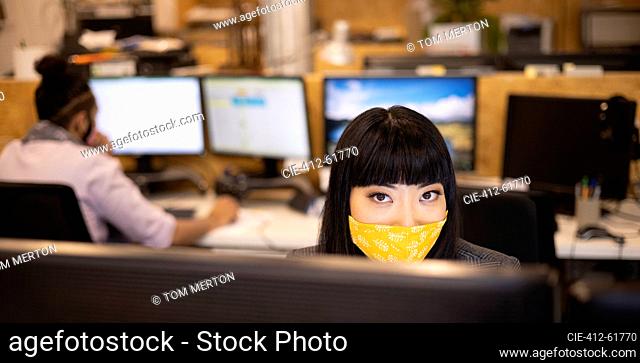 Portrait confident businesswoman in face mask working in office