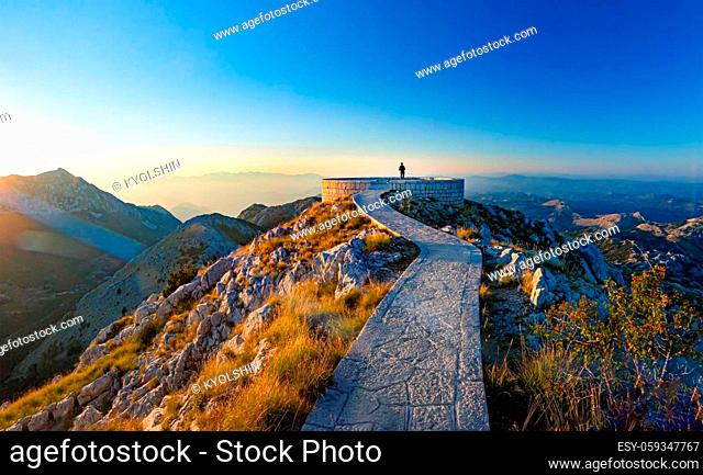 Sunset scene at Mausoleum of Njegos on mountain Lovcen, Montenegro, Europe. Person looking at mountains