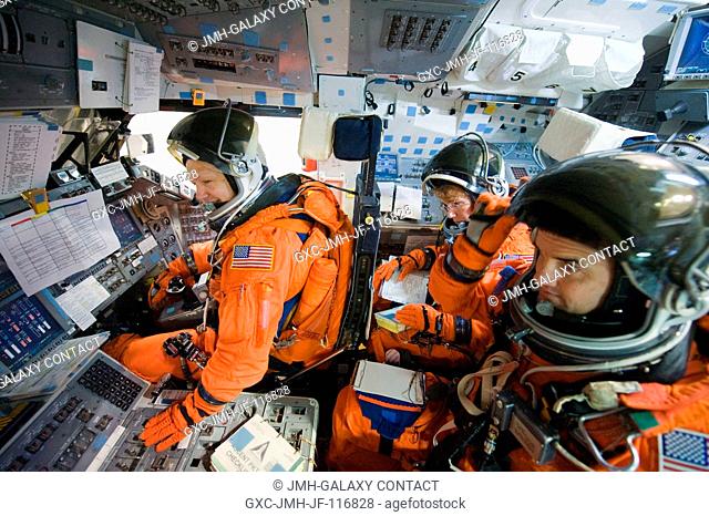NASA astronauts Doug Hurley (left), STS-135 pilot; Rex Walheim and Sandy Magnus, both mission specialists, attired in training versions of their shuttle launch...