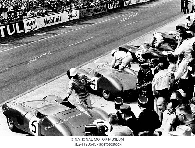 Start of the Le Mans 24 Hours, France, 1959. Roy Salvadori prepares to climb aboard his Aston Martin DBR1 (no 5), while Stirling Moss leaps into his (no 4)