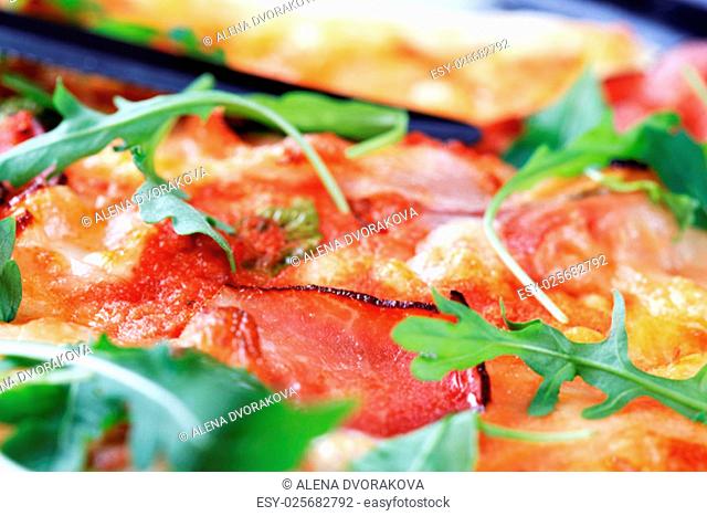 Slices of prosciutto ham on pizza - macro