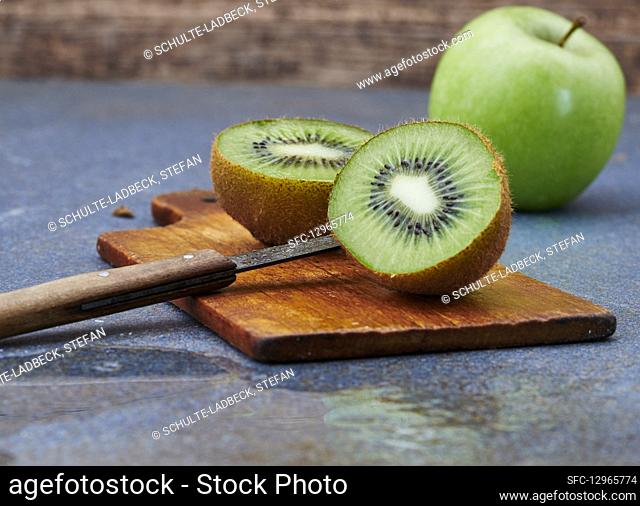 A halved kiwi on a wooden board