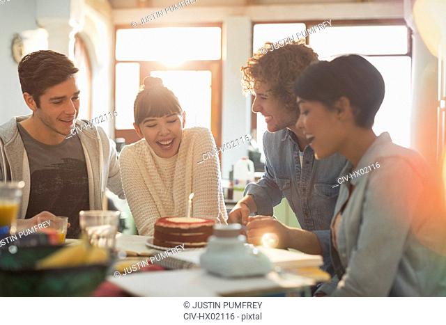 Young couple friends celebrating birthday with cake and candle